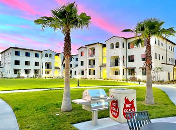 A bench with a sign that says Hot Coals is in front of a building.